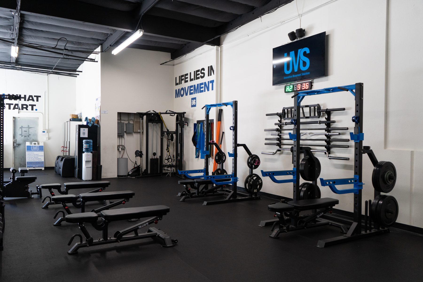 The IMS strength training floor with squat racks, benches, and the IMS branding on the wall